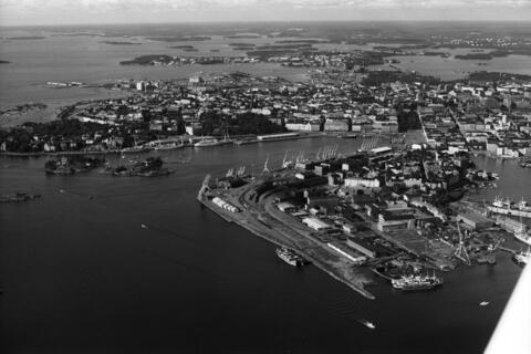 Viistoilmakuva pienlentokoneesta Kruunuvuorenselän, Katajanokan itäkärjen suunnalta lounaaseen. Oikealla Katajanokka. Vasemmalla Luoto ja Valkosaari sekä Kaivopuisto, keskellä Eteläsatama, oikealla Kaartinkaupunki, Kruununhakaa ja Kluuvia.