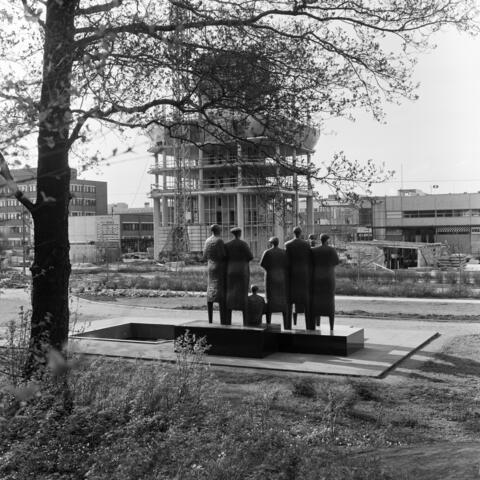 Skulpturen Vänner och byamän. I bakgrunden syns halvfärdiga byggnader.