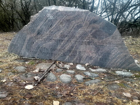 Stenstod med texten TÄMÄ MÄKI ON OLLUT MESTAUSPAIKKANA 1700-LUVULLA DETTA OMRÅDE HAR FUNGERAT SOM AVRÄTTNINGSPLATS PÅ 1700-TALET.