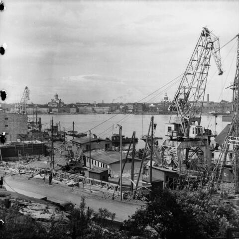 Construction cranes next to the terminal building by the sea