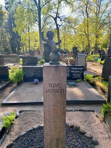 Kapeassa korkeahkossa punagraniittipaadessa lukee TOVE JANSSON. Paaden päällä on pieni pronssiveistos, joka esittää pallon päällä istuvaa pikkulasta.