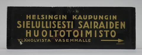  Mustalla pohjalla kullanvärinen teksti: Helsingin kaupungin sielullisesti sairaiden huoltotoimisto yläholvista vasemmalle