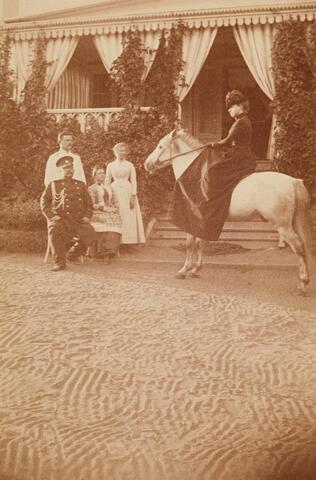 Munkkiniemen kartanon edustalla vapaaherra, kenraali Georg Edward Ramsay (1834-1918) ja vapaaherratar Elisabeth Ramsay o.s. Cumming. Seisomassa heidän poikansa Edward Aleksander (s. 1862) ja tämän puoliso, Isabella Elisabeth (Isa) Rosinsky o.s. Rosinsky. Ratsailla kenraali Ramsayn tytär Johanna Eleonora (Jane) Eleonora (s. 1863).