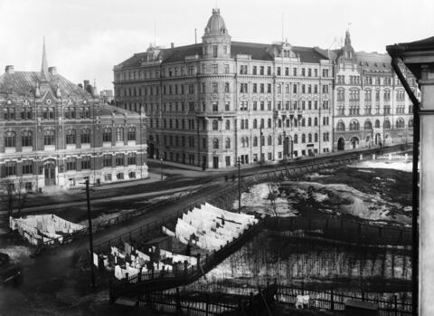 Kevättalvella otetussa kuvassa näkyy maassa lunta. Etualalla on pyykkiä kuivumassa, keskellä on Korkeavuorenkatu ja sen varrella nykyinen Designmuseo ja niin sanottu Ohranan talo.