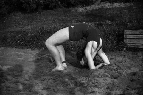 Nainen on taivuttanut vartalonsa taaksepäin niin, että se muodostaa sillan.