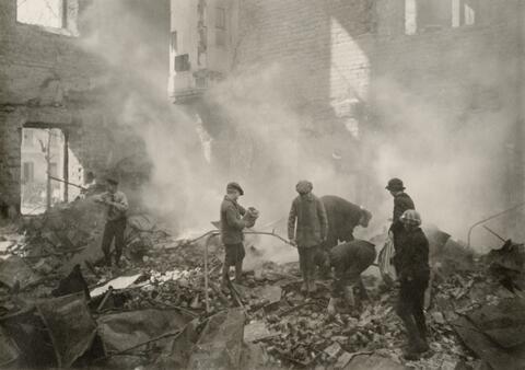 En skara barn bland ruinerna av en bombarderad byggnad.