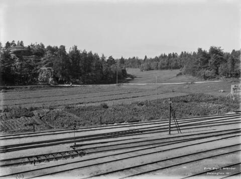 Näkymä länteen hieman Pasilan aseman pohjoispuolelta vuonna 1911. Nykyään täysin rakennetun ympäristön paikalla on peltoaukeaa ja metsiä.