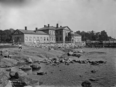 Brunnsparkens badinrättning sett från södra stranden, i förgrunden klippor och en brygga.