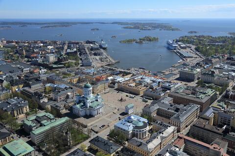 Ilmasta otettu kuva, jossa näkyy etualalla Senaatintoria ympäröiviä rakennuksia. Taaempana näkyy mm. Katajanokka, merta sekä saaristoa.