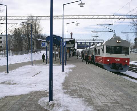 Kuva Tapanilan juna-asemasta. Lähijuna P seisoo raiteilla. Maassa on lunta.