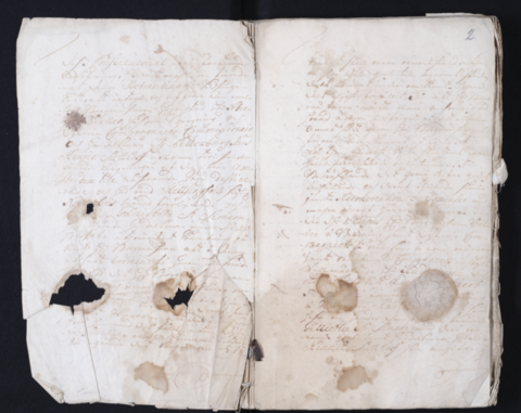 A handwritten document with holes and stains.