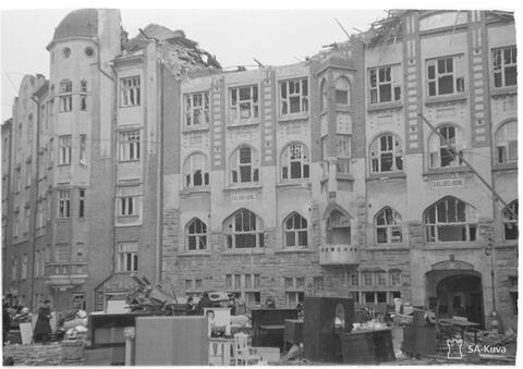 A damaged building with furniture outside of it