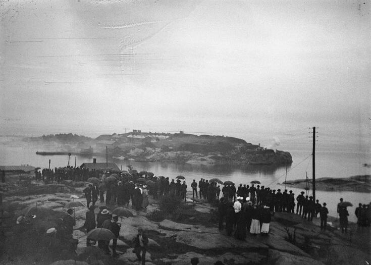 Människor står på Brunnsparkens strand och tittar mot Sveaborg