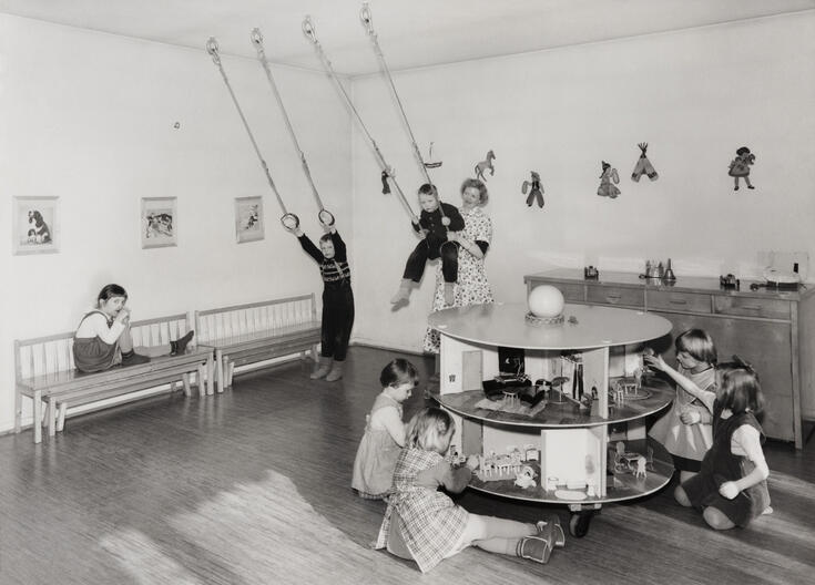 Lapset leikkimässä ja keinumassa Arabian lastentalossa.