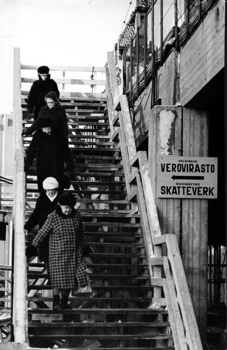 Fem personer i vinterkläder går i en trappa utomhus. Trappan är ganska brant och alla håller i räcket. Till höger syns betongkonstruktioner i Havshagen.