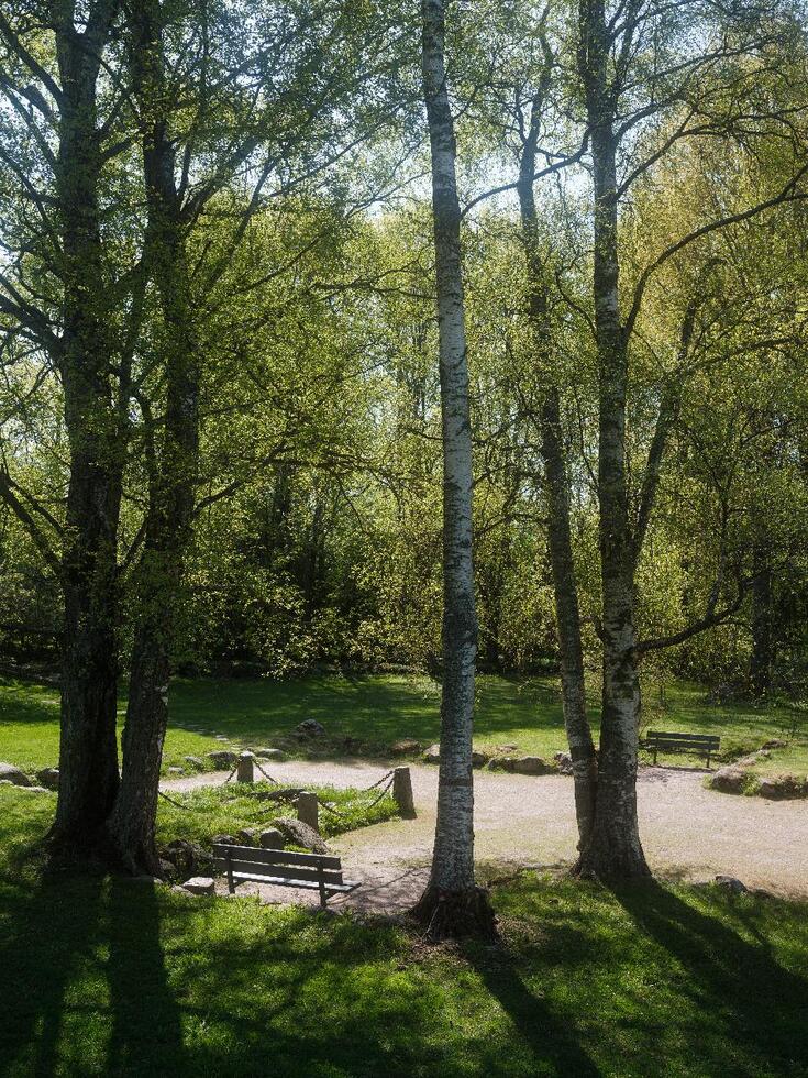 En sandplan formad som ett kors och kantad med stenar, minnesmärke för Helsingfors första kyrka.