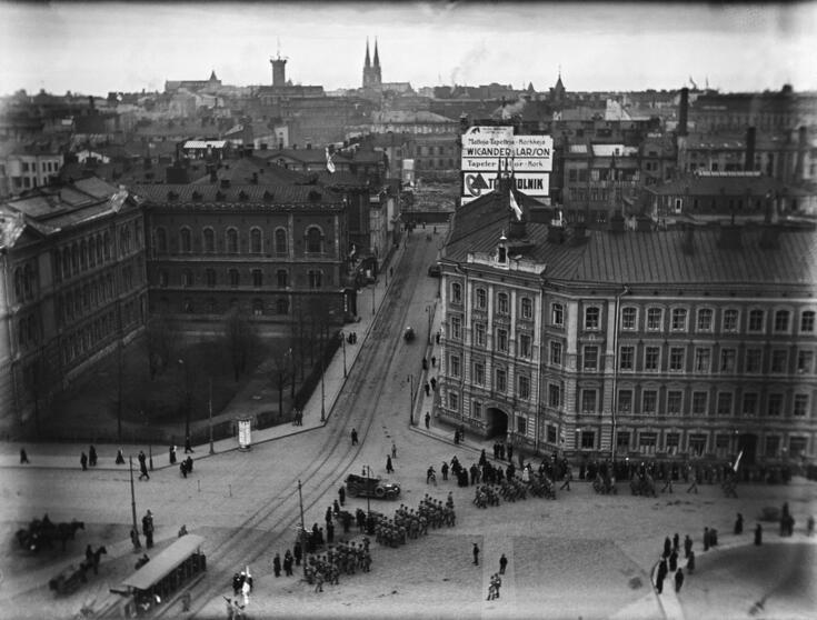 Näkymä Rautatieaseman tornista Hakasalmenkadun (= Keskuskatu) ja Kaivokadun risteykseen. Vasemmalla Ateneum, Hakasalmenkatu 1 (= Keskuskatu 9) ja Hakasalmenkatu 3 (= Keskuskatu 7), Vapaapalokunnan (VPK:n) talo. Oikealla Hakasalmenkatu 2 (= Keskuskatu 8). Arkkitehdit Theodor Höijer ja F.A. Sjöström. Skohan talona tunnettu rakennus valmistui 1870-luvulla ja purettiin 1965. Taustalla Hakasalmenkatua jatketaan kohti Esplanadia.