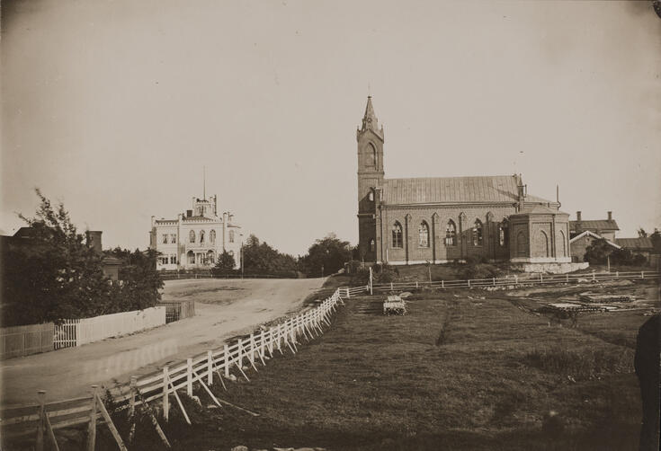 Till höger finns Sankt Henriks romersk-katolska katedral, arkitekt Ernst Bernhard Lohrmann 1860, Paulusgatan (numera Sankt Henriksplatsen 1). Till vänster finns den så kallade Spåres villa, nuvarande Östra Allén 1, fotograferad från Ulrikagatan mot sydsydost. Bredvid kyrkan finns en inhägnad beteshage och brädstaplar. Trävillan har rivits och på dess plats ligger byggnaden som kallas Marmorpalatset, arkitekt Eliel Saarinen 1918.