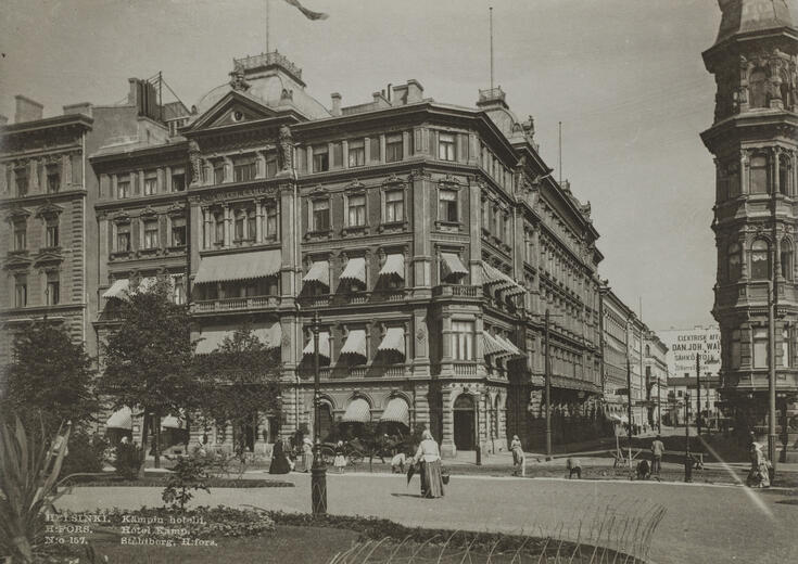 Hotell Kämp, Norra Esplanaden 29. Till höger Glogatan. Framför hotellet syns hästdragna vagnar, på Esplanaden syns människor.