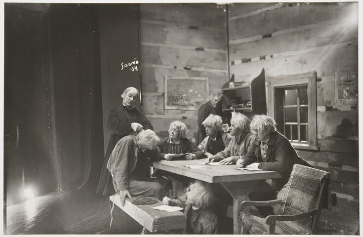 Runt bordet från höger: Uuno Montonen, Unto Salminen, Eero Eloranta, Aku Korhonen, Tauno Palo och en oidentifierad (under bordet), i hörnet Yrjö Tuominen och som klockare Uuno Laakso