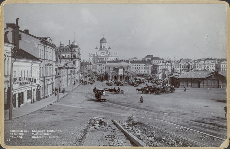 Postikortti, jossa on vasemmalla Eteläranta 6, 8 ja 10 ja oikealla ihmisiä ja hevoskärryjä kauppahallin eteläpuolella. Satama-altaassa on purjelaivoja. 