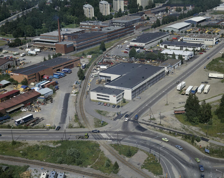 Ilmakuvassa Mertakatua Toukolassa, liikenneväyliä ja tuotantorakennuksia.