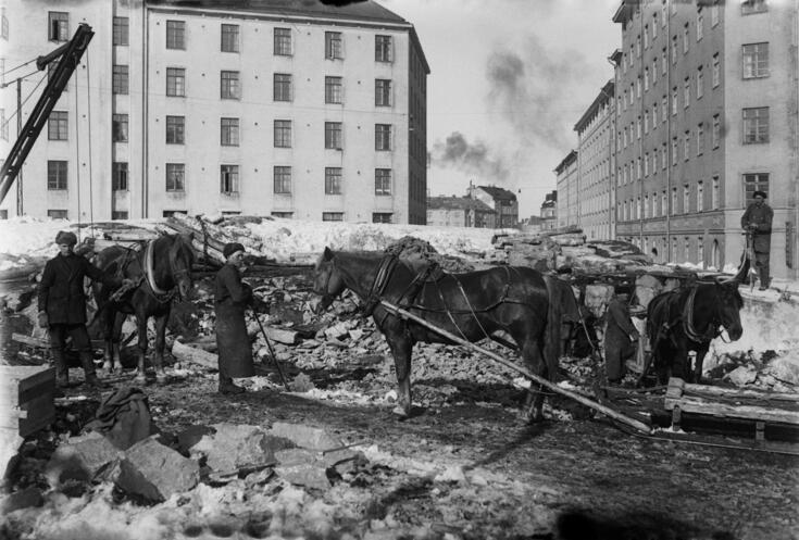 Maanrakennustöitä Torkkelinmäellä talvella, etualalla työmiehiä ja kuormahevosia. Taustalla vas. Pengerkatu 18 (Franzeninkatu 1), oik. Pengerkatu 23 (Torkkelinkatu 3).