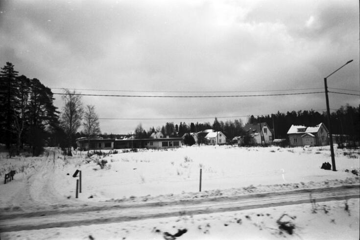 Lumisia maisemia kuvattuna junan ikkunasta matkalla Helsingistä Tampereelle. Näkymä junasta Kiitäjäntielle. Alviontie 4 tasakattoinen omakotitalo. harjakattoisten puutalojen keskellä.