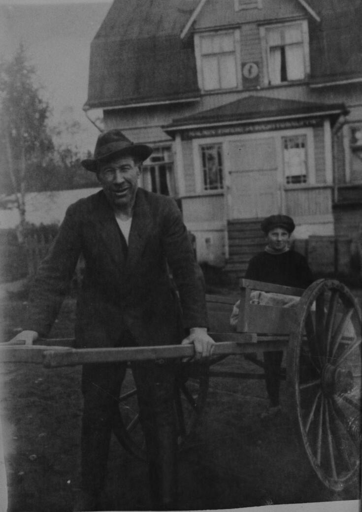  Isä ja poika palaamassa perunannostosta Malmilla, nykyisellä Kirkonkylän tiellä, Flinkenbergin kirjakaupan edessä.