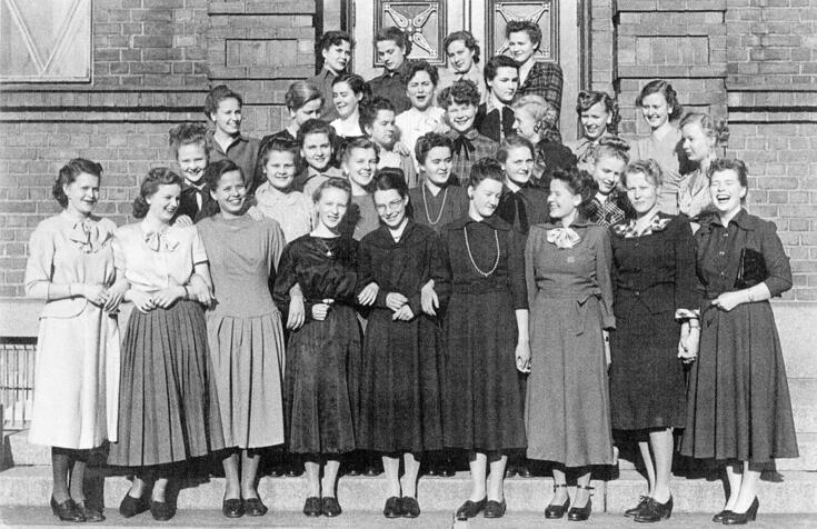 Tyttönormaalilyseon vanhojenpäivä. Vanhoja koulun edessä ryhmäkuvassa 1949. Vanhat korostivat kypsyyttään pukeutumalla huippumuodikkaasti Diorin New lookin mukaan.