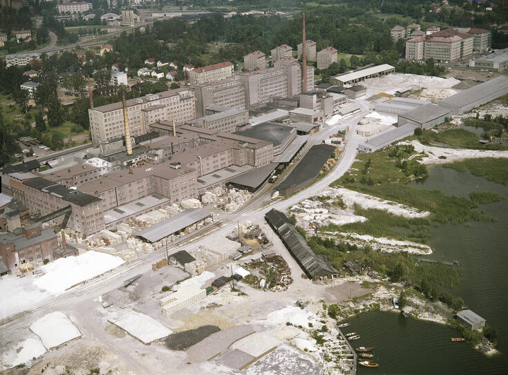 Ilmakuvassa Arabian tehdasrakennukset. Takapihalla näkyy junaraiteet ja junavaunuja.