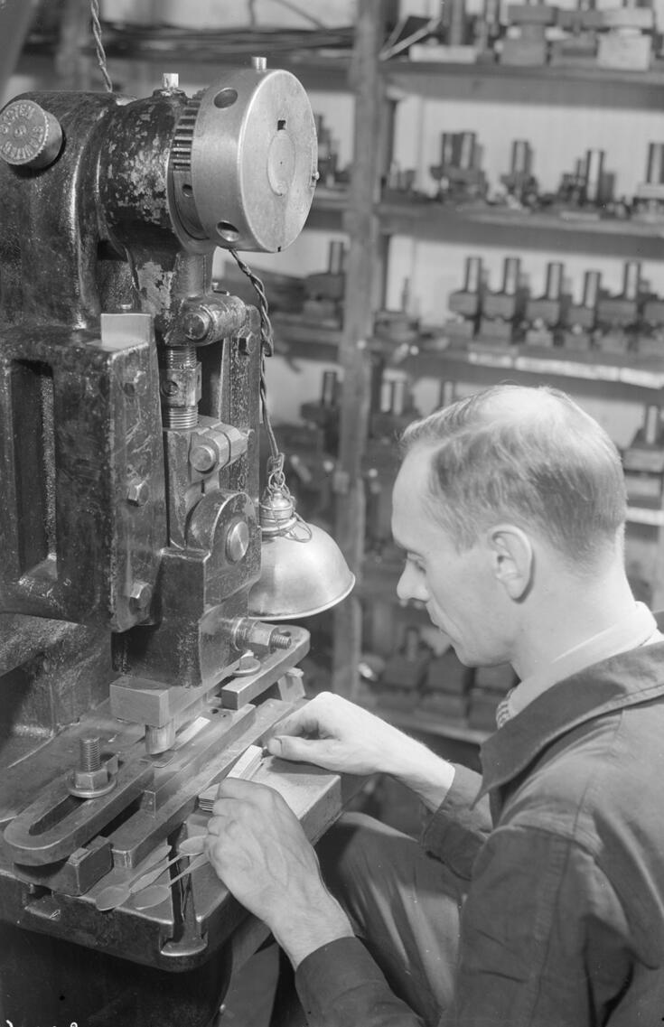 A man operating a machine in the factory of Hopeatehdas Oy