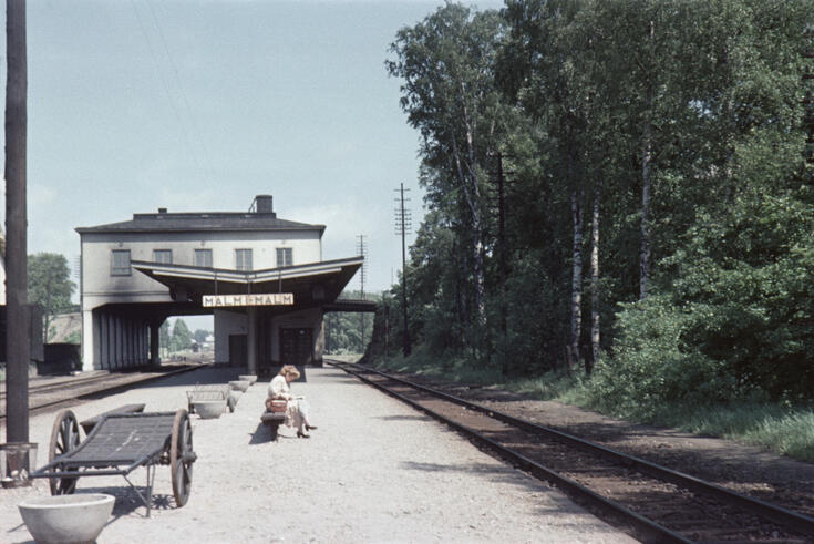 Valkoinen asemarakennus, joka on rakennettu junaraiteiden päälle 1932.
