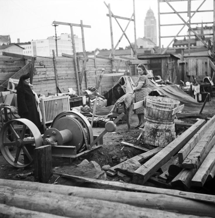An old woman and a younger one with a child in the middle of rubble