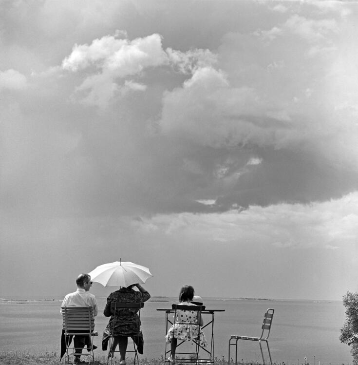 Suomenlinna, Susisaari. Perhe Piperin kahvilassa rannassa selin kameraan. 