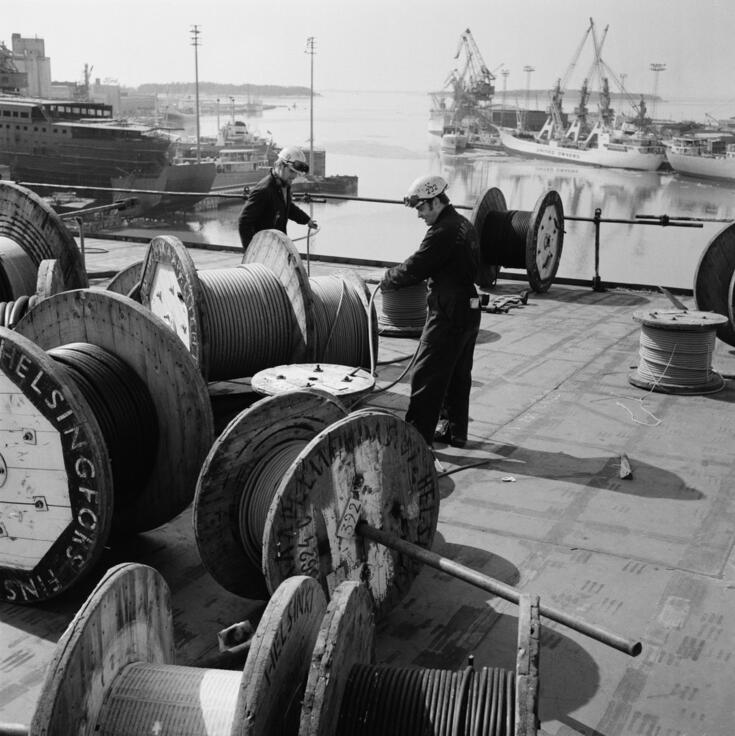 Työnteon dokumentointia: työmiehet kaapelikelojen kimpussa Oy Wärtsilä Ab:n Helsingin telakalla vuonna 1970.