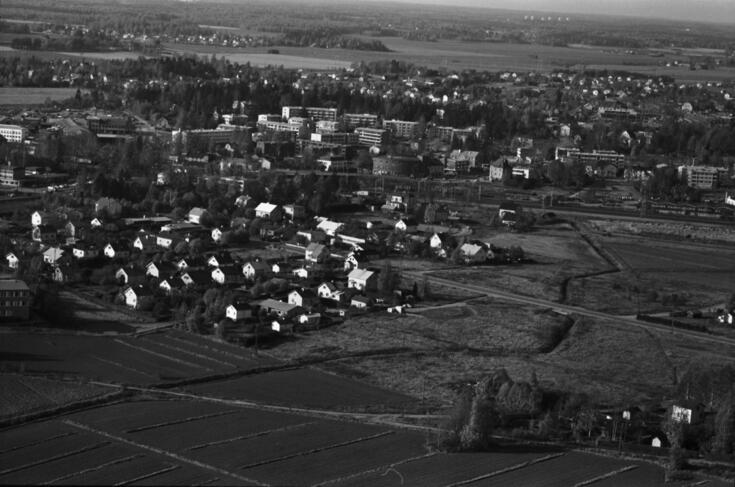 Viistoilmakuva pienlentokoneesta Malmilta Vanhanradanraitin suunnalta länteen. Keskellä Vilppulantie, vasemmalla pientaloja. Taustalla päärata, sen takana keskellä Malmin Elannon kaareva tiilirakennus Kirkonkyläntiellä. Taustalla Markkinatien, Anianpellontien ja Kunnantien kerrostaloja.
