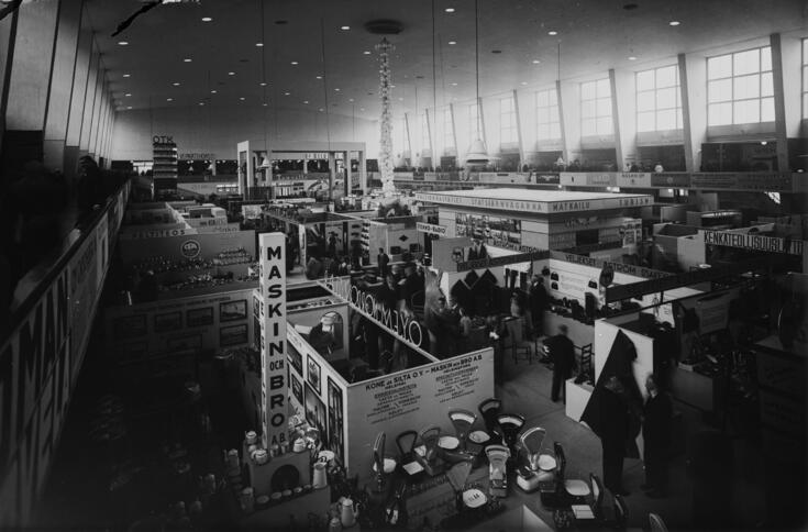 Yleisnäkymä messuosastoille, joilla näkyy vaakoja ja muita teknisiä laitteita.