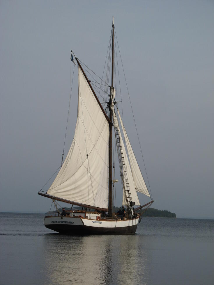 Yksimastoinen pienehkö purjealus kuvattuna merellä.