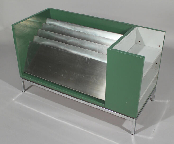 Mörkgrönt tidningställ tillverkat av trä och aluminium