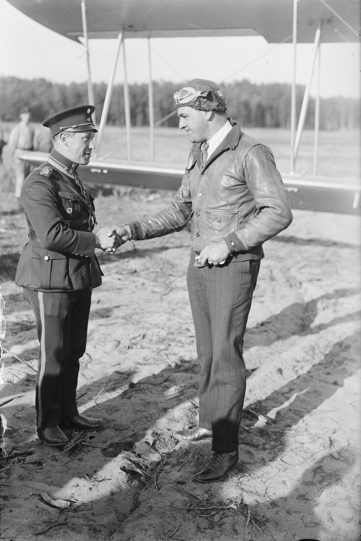 Överste Väinö Vuori, befälhavare för Finlands luftstridskrafter, skakar hand med en officer ur Förenta staternas flygvapen på flygfältet i Sandhamn år 1930. 