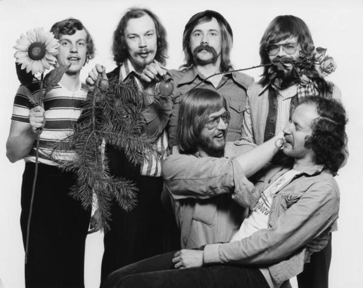 Kulutusosuuskuntien Keskusliiton (KK; v:sta 1983 Kulutusosuustoiminnan Keskusliitto) E-discon tiskijukat esittelevät tunnuksiaan vuonna 1973. Seisomassa vasemmalta Börje, Make, Jokkeja Oscu ja istumassa Lisko ja Takku. E-discoja järjestettiin KK:n valistusosaston 27.8.1973 - 7.12.1973 toteuttaman E-nuorisokiertueen yhteydessä 70 eri tilaisuudessa ympäri maata.