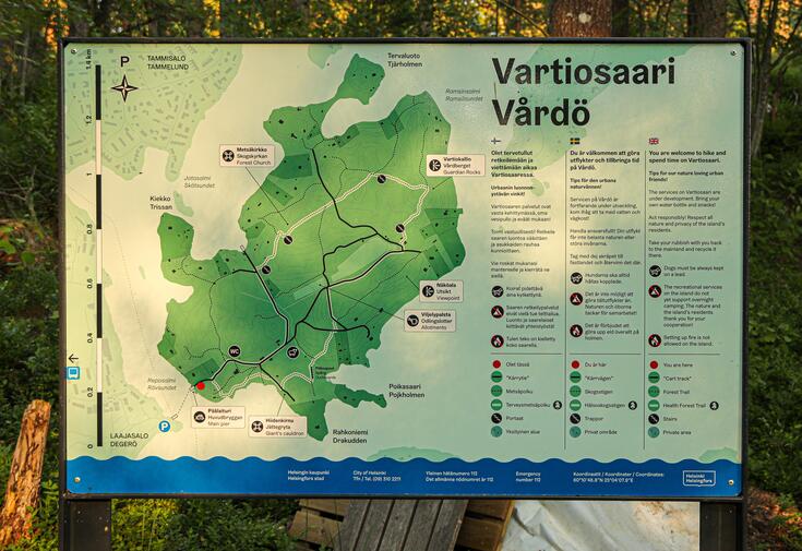 Vartiosaaren opastaulu, jossa on kuvattu saaren kulkureitit ja tärkeät kohteet.