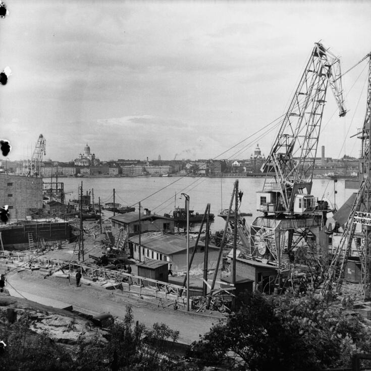 Construction cranes next to the terminal building by the sea