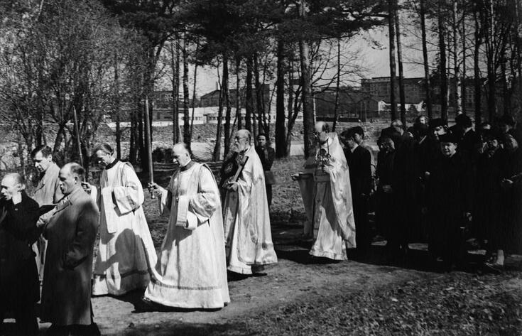 Påskprocession med ljusbärare, kör, präster och kyrkfolk.