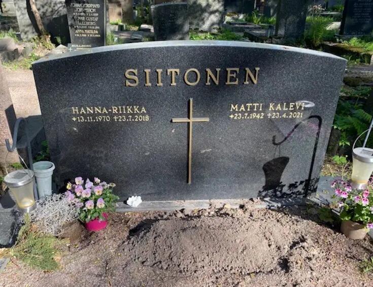 Yksinkertainen musta graniittipaasi, jonka yläreunassa lukee SIITONEN ja keskellä on metalliristi. Ristin vasemmalla puolella teksti HANNA-RIIKKA s. 13.11.1970, k. 23.7.2018 ja oikealla puolella MATTI KALEVI s. 23.7.1942, k. 23.4.2021