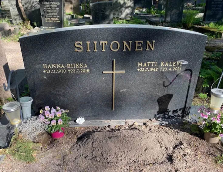 Yksinkertainen musta graniittipaasi, jonka yläreunassa lukee SIITONEN ja keskellä on metalliristi. Ristin vasemmalla puolella teksti HANNA-RIIKKA s. 13.11.1970, k. 23.7.2018 ja oikealla puolella MATTI KALEVI s. 23.7.1942, k. 23.4.2021