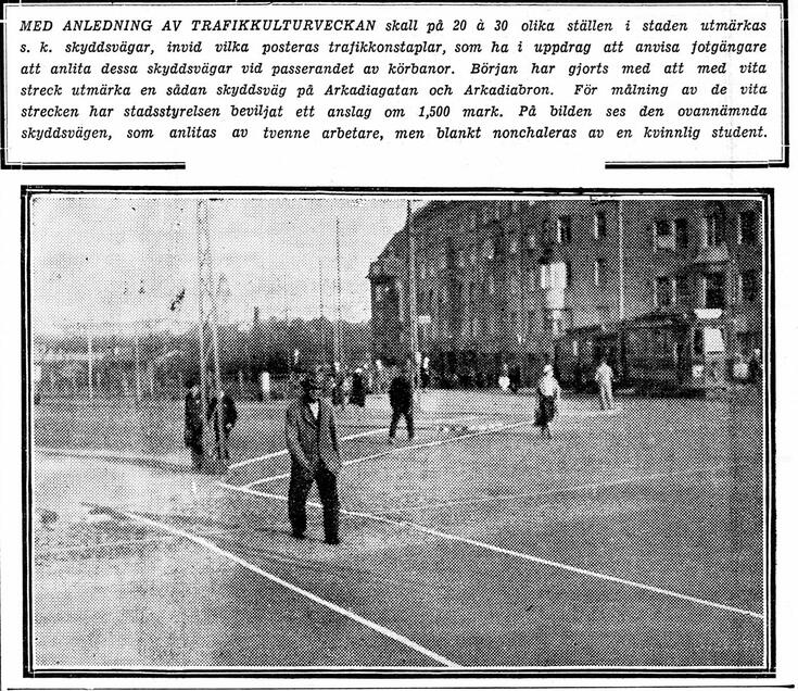 Kuvakaappaus lehdessä julkaistusta kuvasta ja kuvatekstistä. Kuvassa näkyy risteys, jossa tiehen on maalattu valkoisin viivoin kaistoja, joilla kävelee ihmisiä. Kuvateksti kommentoi, että kaikki eivät ymmärrä kävellä noilla suojateillä. 