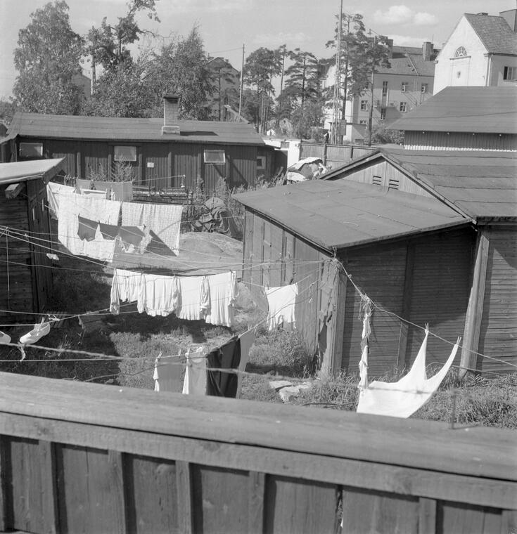 Träbaracker i hörnet av Viborgsgatan och Kotkagatan. Byk hänger på tork på gården.