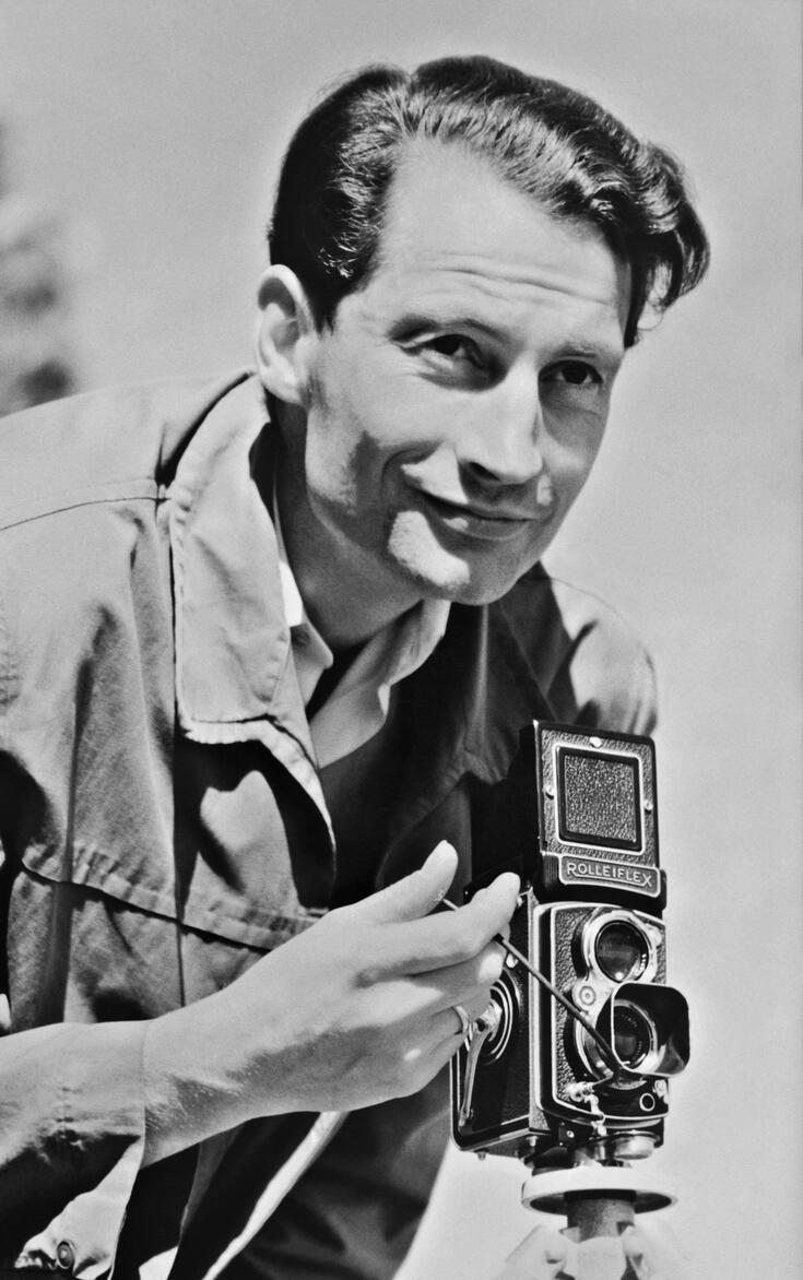 Lähikuva miehestä, jolla on kädessään kamera